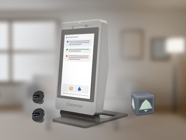 The home device on a folding stand: the conversation split by speaker, each in its own colour.